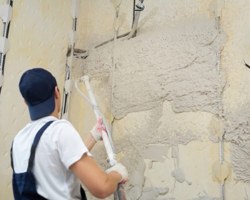 The process of applying plaster to walls inside a building by machine